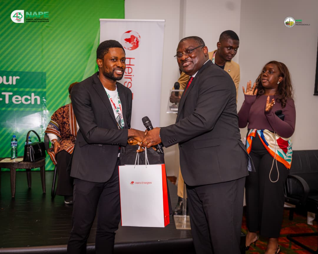 A winner receiving his prize from the Heirs Energies representative